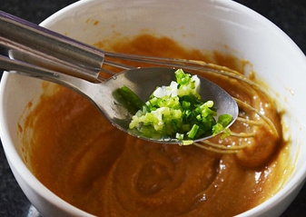 Додаємо в соус подрібнений зелений лук і імбир