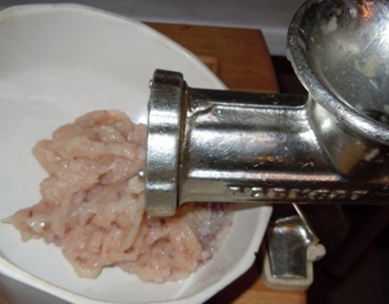 З допомогою м'ясорубки робимо з шматочків курки фарш