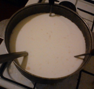 вставляємо ополоники в каструлю з молоком