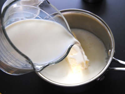 в ємність викладаємо вершкове масло і виливаємо молоко