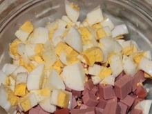 Викладаємо ковбасу до інших інгредієнтів в салатницю