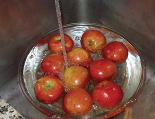 Промиваємо яблука під водою