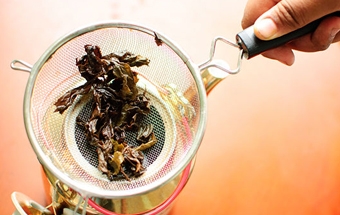 переливаємо чай через сито в чашку