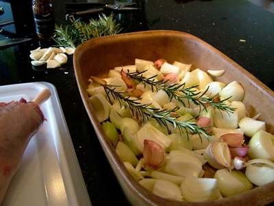 викладаємо на деко цибулю, зубчики часнику і гілочки розмарину